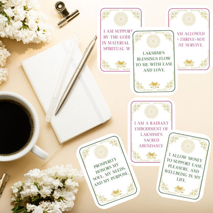 Lakshmi Sacred Abundance affirmation cards displayed on a desk with journal and coffee, showing printable daily affirmations for abundance, prosperity, and embodied self-worth