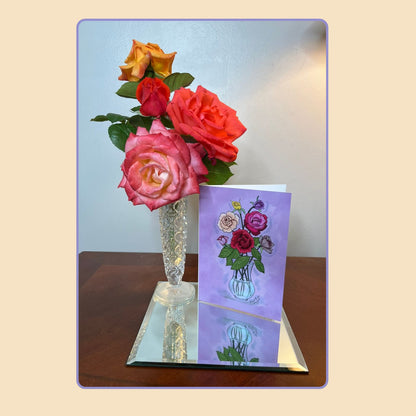Roses note card from the Blooming Expressions set by Tora Moon, displayed beside a vase of pink and orange roses and a lamp. A graceful lifestyle photo highlighting the romantic floral art design.