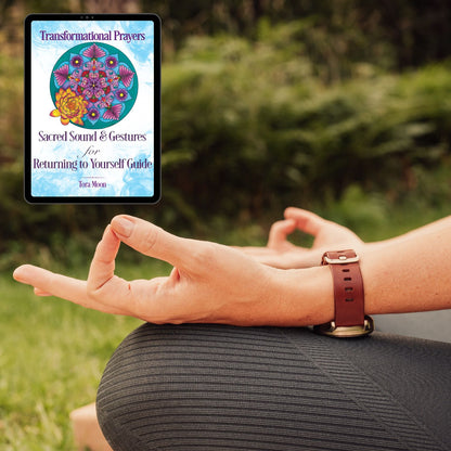 Close-up of a woman practicing a hand mudra outdoors with the Transformational Prayers digital Guide shown beside her.